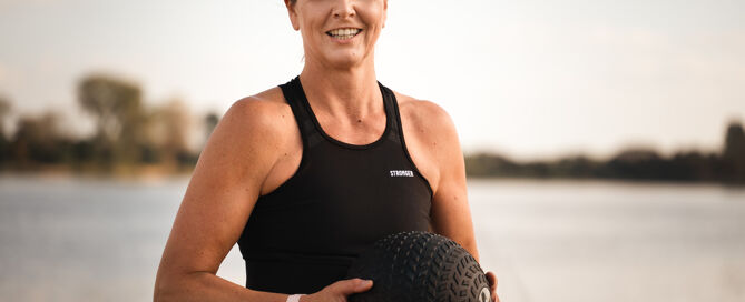 Mona von mova mit Sportausstattung vorm Wasser.