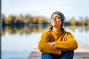 Lächelnde Frau sitzt am See