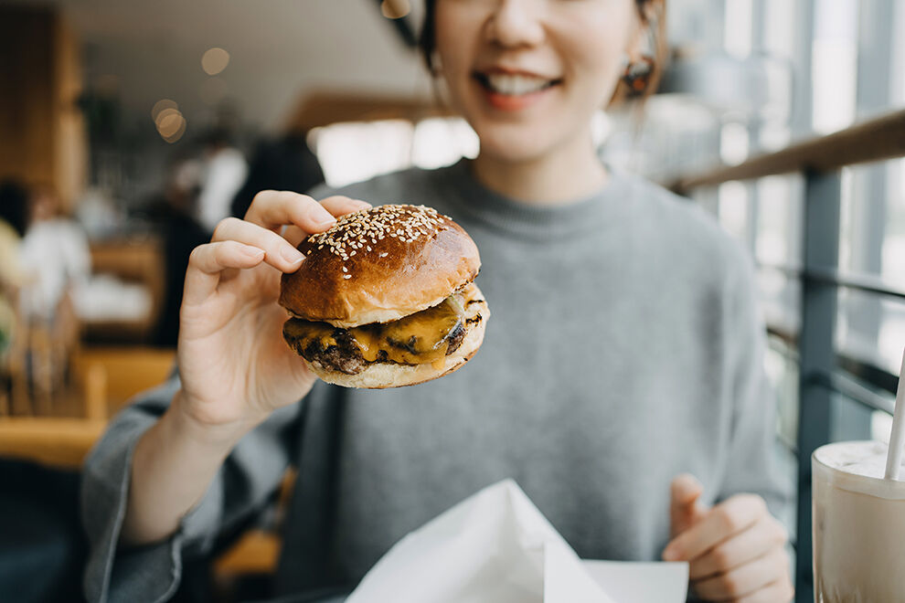 Frau hat einen Burger in der Hand