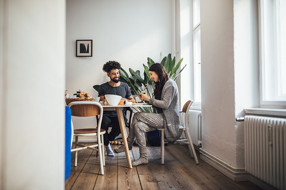 Lächelndes junges Paar beim Frühstück zu Hause