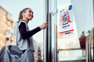 Eine Frau geht in ein Fitnessstudio, öffnet die Tür