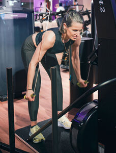 Eine Frau im Fitnessstudio und arbeitet mit Gewichten