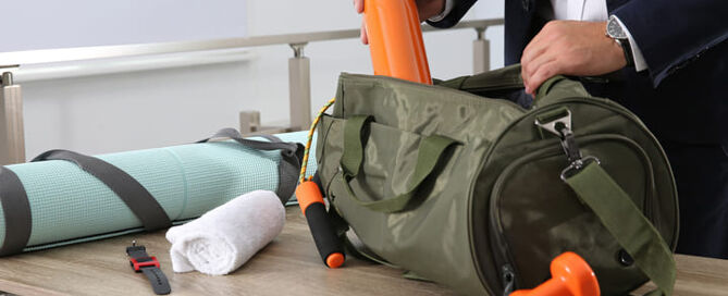 Ein Mann in Anzug packs seine Sporttasche