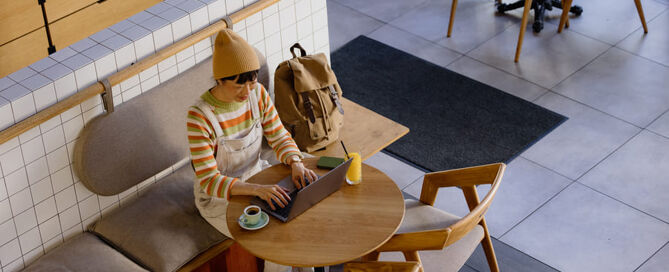 Hybrides Arbeiten: Eine Frau arbeitet an ihrem Laptop in einem Cafe