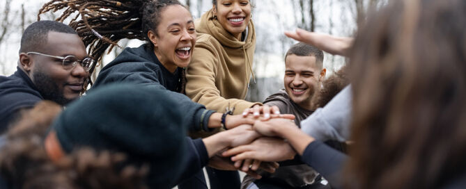 Eine Gruppe von Menschen steht in einem Kreis und jubeln.